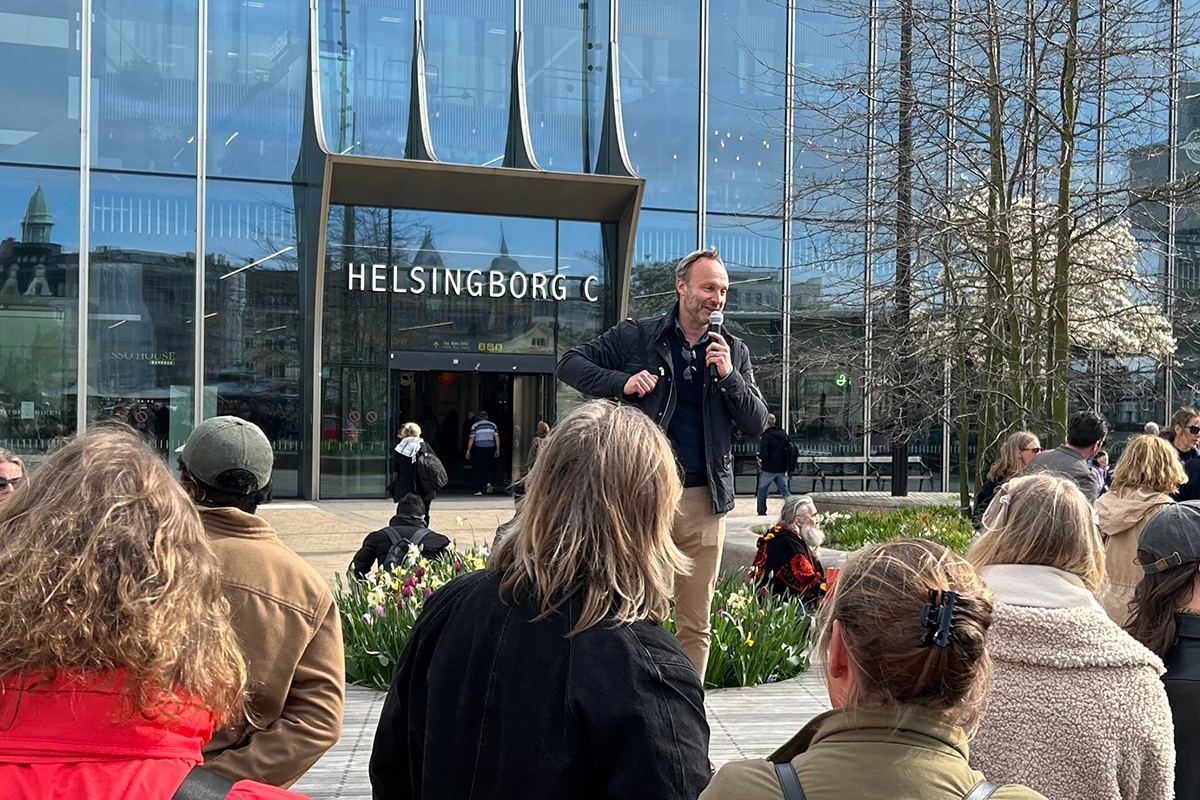 Helsingborgs stadsträdgårdsmästare Martin Hadmyr talar framför grupp av människor vid Helsingborg C. Foto.
