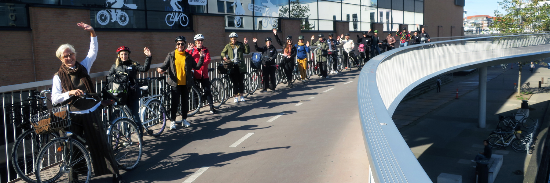 Människor och cyklar på cykelbro. Foto.