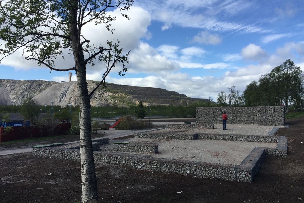 Träd och husgrund, i bakgrunden Kiruna-gruvan. Foto.