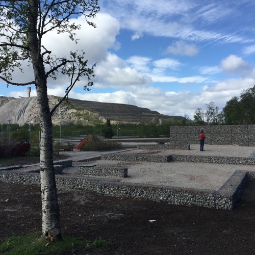 Träd och husgrund, i bakgrunden Kiruna-gruvan. Foto.