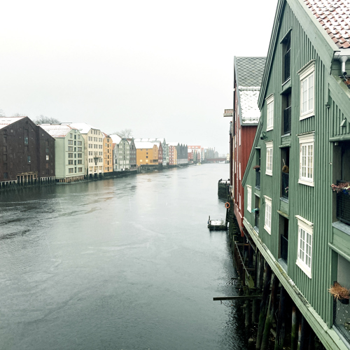 Pastellfärgade hus längs vattnet. Foto.