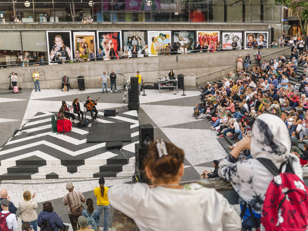 Musiker på scen och publik på trapporna på Sergels torg. Foto.